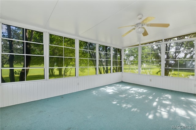 unfurnished sunroom featuring ceiling fan and a wealth of natural light