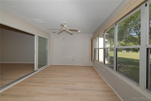 unfurnished sunroom featuring ceiling fan