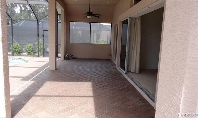 unfurnished sunroom featuring ceiling fan and a pool