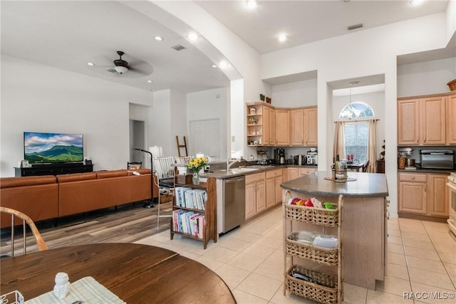 kitchen with dishwasher, light brown cabinets, ceiling fan, light tile patterned floors, and a kitchen island