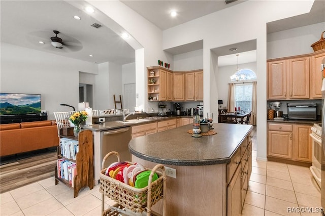 kitchen with light brown cabinets, ceiling fan with notable chandelier, sink, light tile patterned floors, and a kitchen island