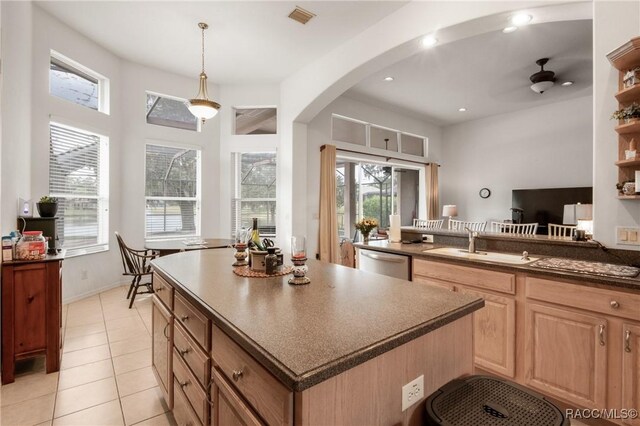 kitchen with ceiling fan, sink, stainless steel dishwasher, decorative light fixtures, and light tile patterned floors