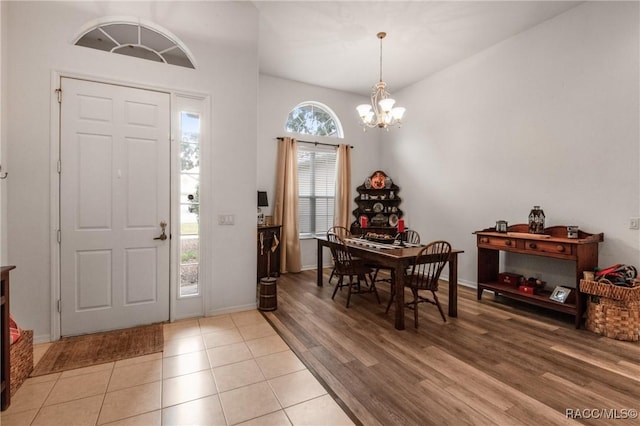 entryway with a wealth of natural light, light hardwood / wood-style floors, and a notable chandelier