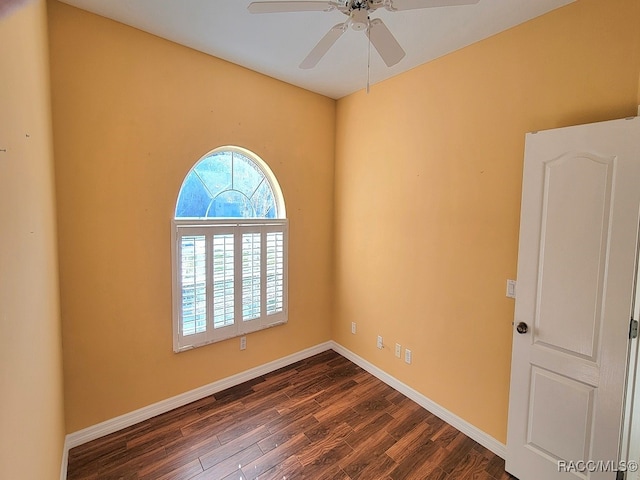 spare room featuring ceiling fan and dark wood-type flooring