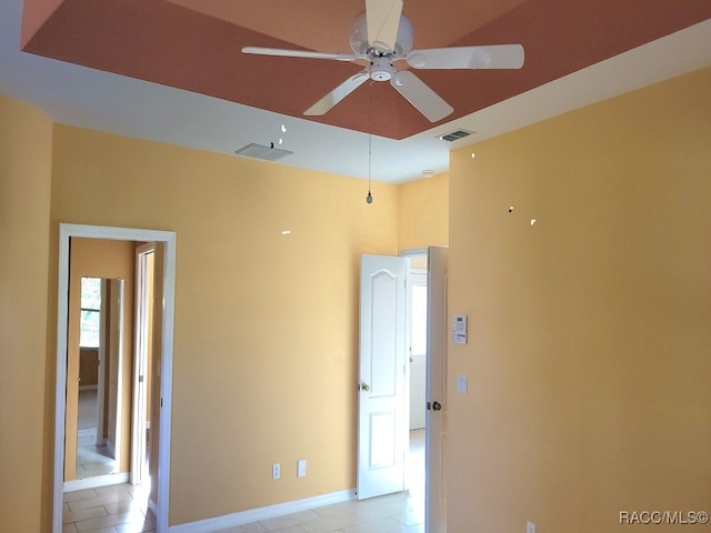 tiled empty room featuring ceiling fan