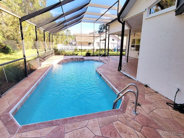 view of swimming pool featuring a patio and glass enclosure