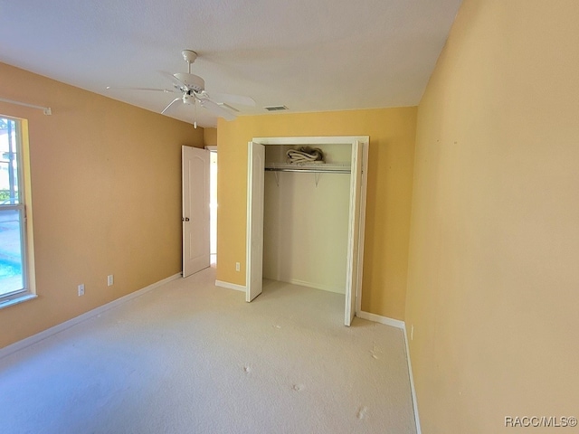 unfurnished bedroom with multiple windows, ceiling fan, a closet, and light carpet