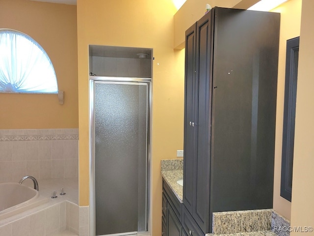 bathroom featuring plus walk in shower and vanity