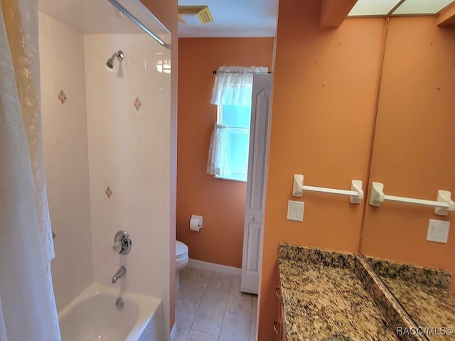 bathroom featuring tiled shower / bath combo and toilet