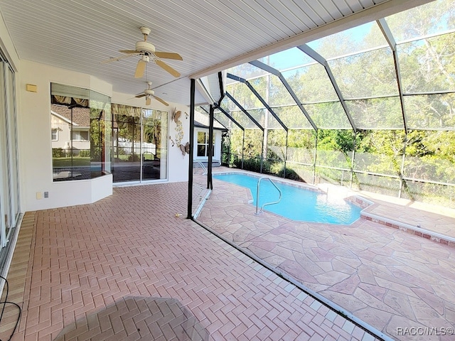 view of pool featuring glass enclosure, ceiling fan, and a patio area