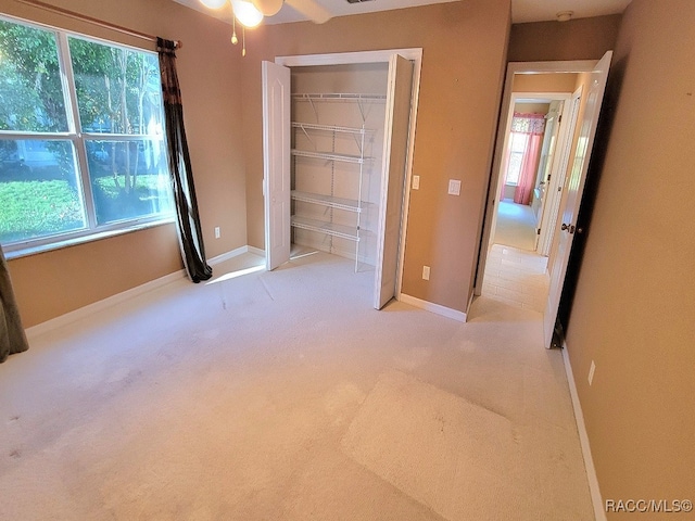 unfurnished bedroom featuring light carpet and a closet