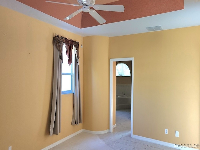 tiled empty room featuring ceiling fan