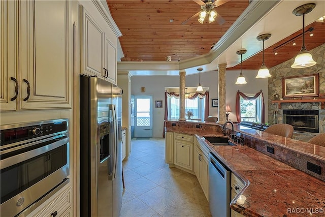 kitchen with a sink, cream cabinetry, wooden ceiling, and stainless steel appliances