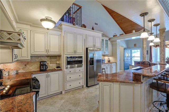 kitchen with glass insert cabinets, a kitchen breakfast bar, a sink, stainless steel appliances, and decorative backsplash