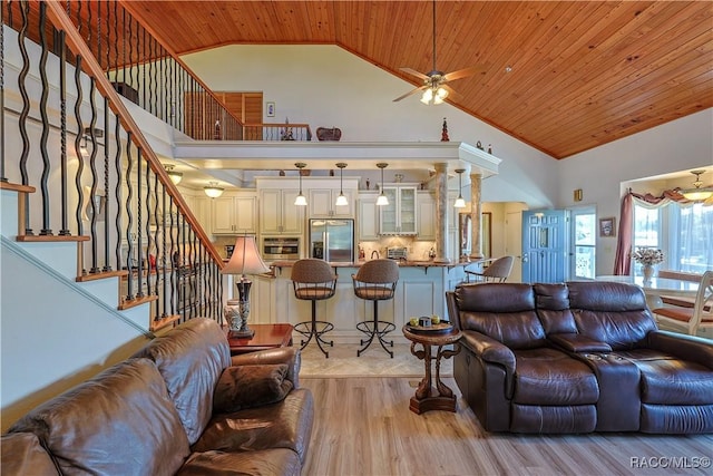 living area featuring high vaulted ceiling, ceiling fan, wood ceiling, stairs, and light wood finished floors