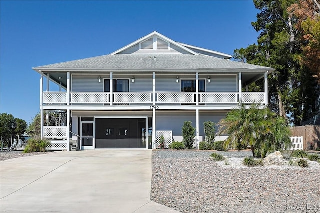 view of front of property featuring an attached garage, a shingled roof, and driveway