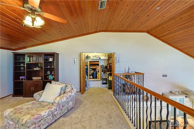 sitting room with vaulted ceiling, a ceiling fan, visible vents, carpet, and wooden ceiling