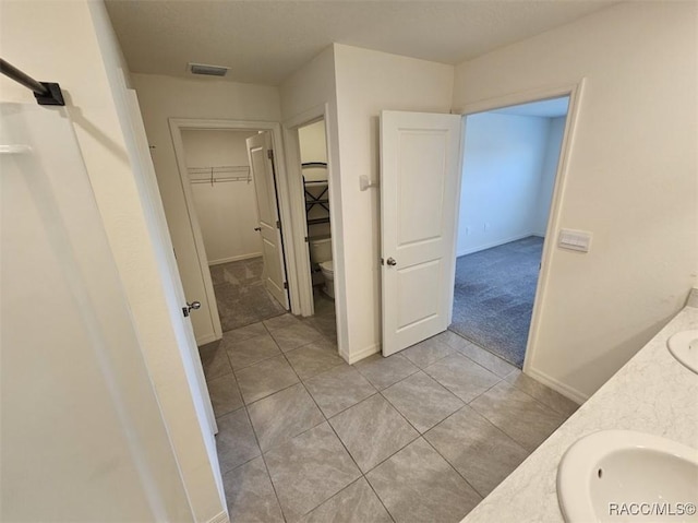 bathroom featuring toilet, vanity, and tile patterned flooring