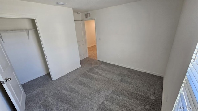 unfurnished bedroom with a closet and dark carpet