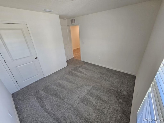 unfurnished bedroom with dark carpet