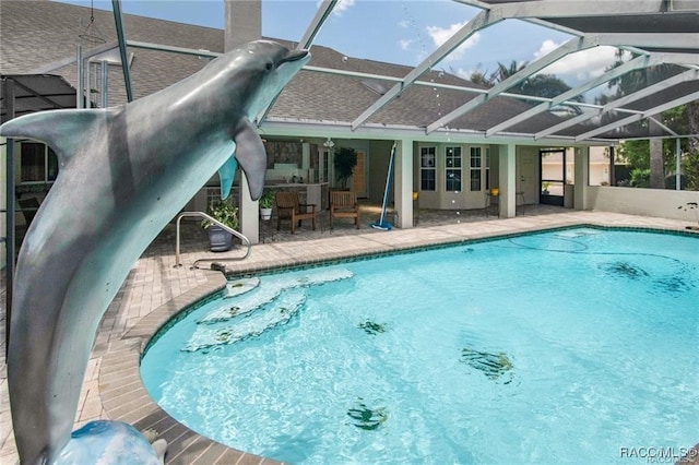 view of swimming pool featuring a patio and a lanai