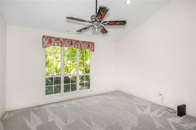 spare room featuring ceiling fan, light colored carpet, and lofted ceiling