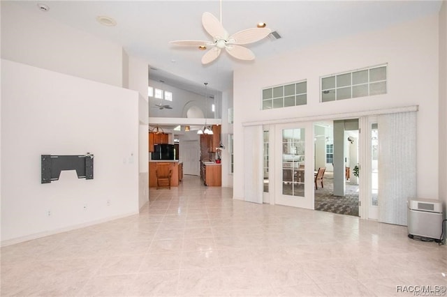 unfurnished living room with ceiling fan, french doors, high vaulted ceiling, and light tile patterned flooring