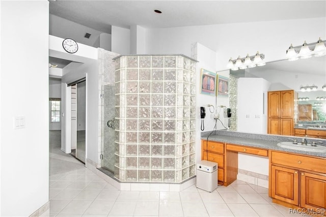 bathroom with a tile shower, tile patterned flooring, and vanity