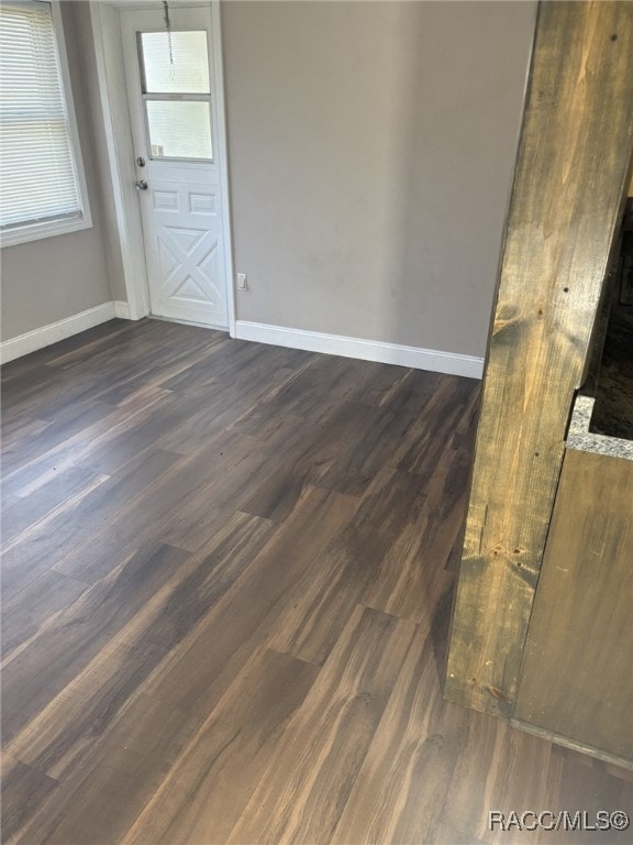 empty room with dark hardwood / wood-style flooring