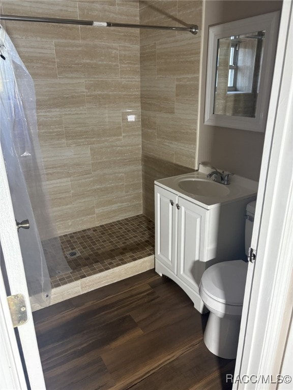 bathroom featuring hardwood / wood-style flooring, toilet, vanity, and a shower with shower curtain