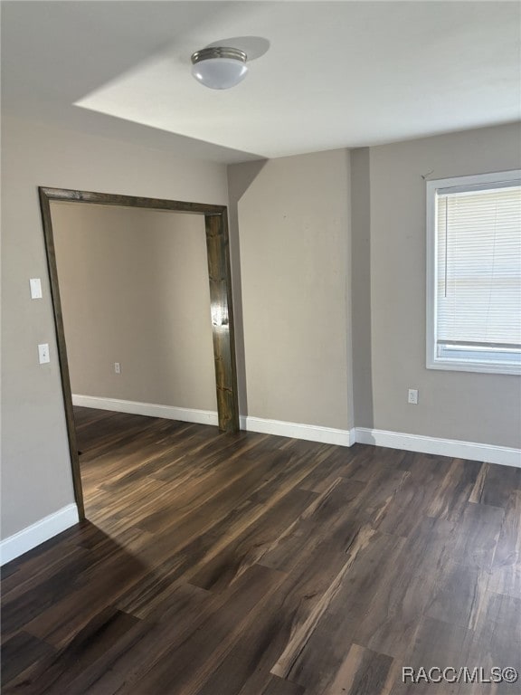 spare room with dark wood-type flooring