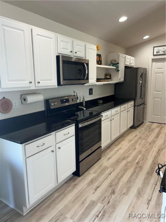 kitchen featuring stainless steel appliances, dark countertops, open shelves, and white cabinets