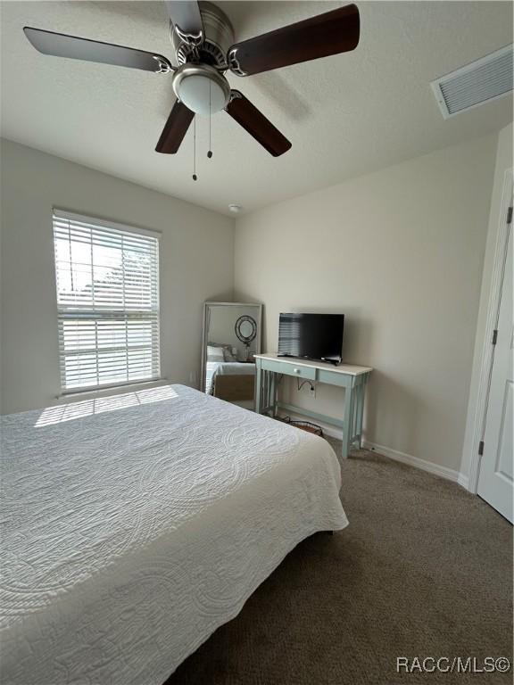 bedroom with ceiling fan, carpet floors, visible vents, and baseboards