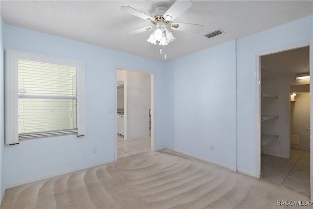 spare room featuring light carpet and ceiling fan