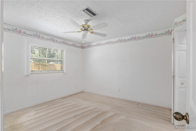 carpeted spare room with a textured ceiling and ceiling fan