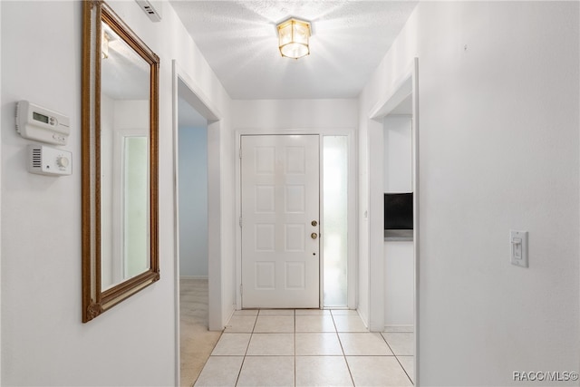 tiled foyer entrance with a textured ceiling