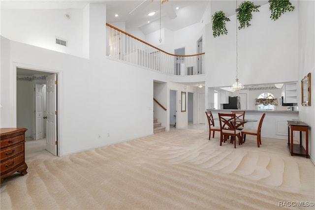 living room with ceiling fan, light colored carpet, and high vaulted ceiling