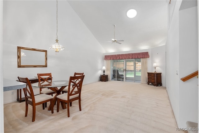 carpeted dining space with high vaulted ceiling and ceiling fan