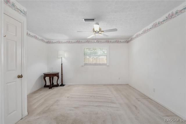 carpeted empty room featuring ceiling fan and a textured ceiling