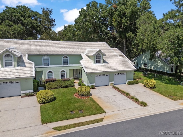 view of front of home with a garage and a front lawn