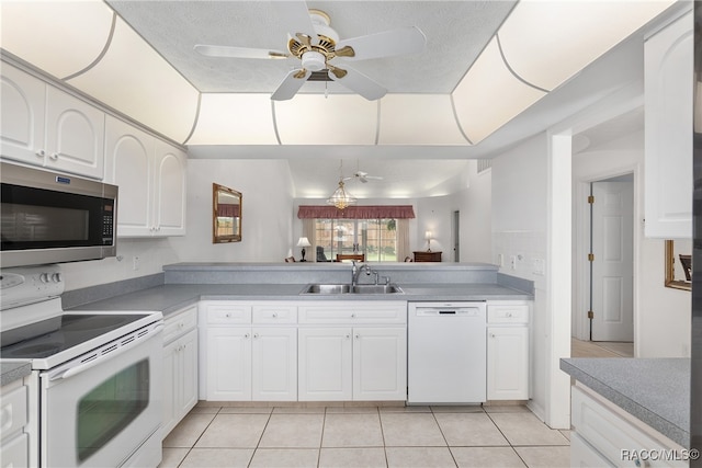 kitchen featuring white appliances, ceiling fan, sink, light tile patterned floors, and white cabinetry