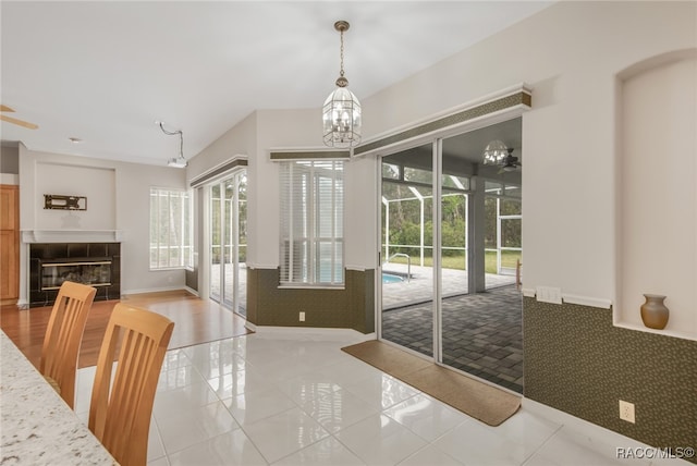 entryway featuring a chandelier, light tile patterned floors, and a tiled fireplace