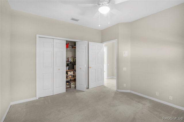 unfurnished bedroom with light carpet, a closet, and ceiling fan