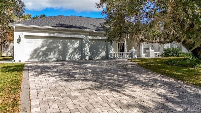 view of front of home featuring covered porch, a garage, and a front yard