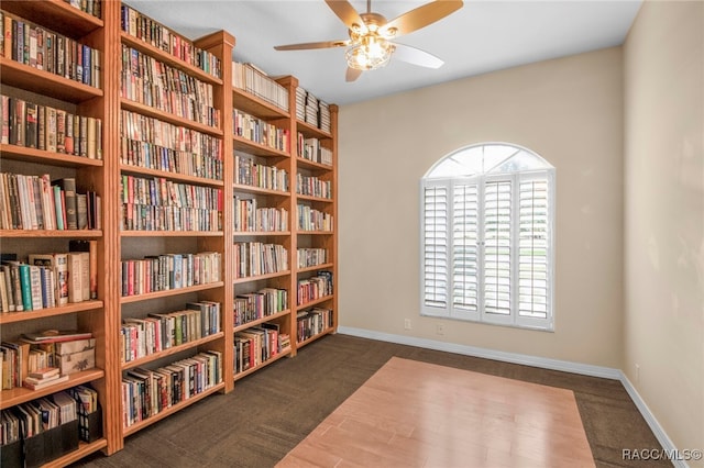 living area featuring ceiling fan and dark carpet