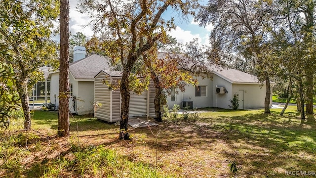 back of property with a yard and central air condition unit