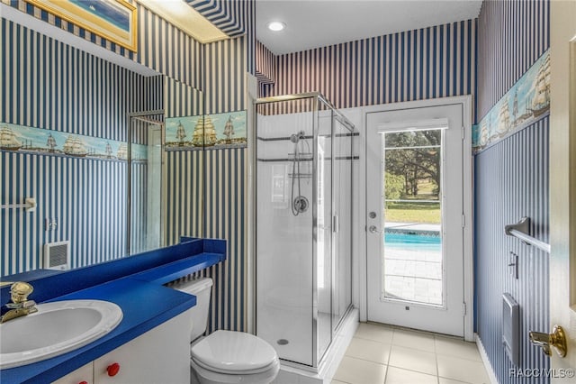 bathroom with tile patterned floors, vanity, toilet, and an enclosed shower