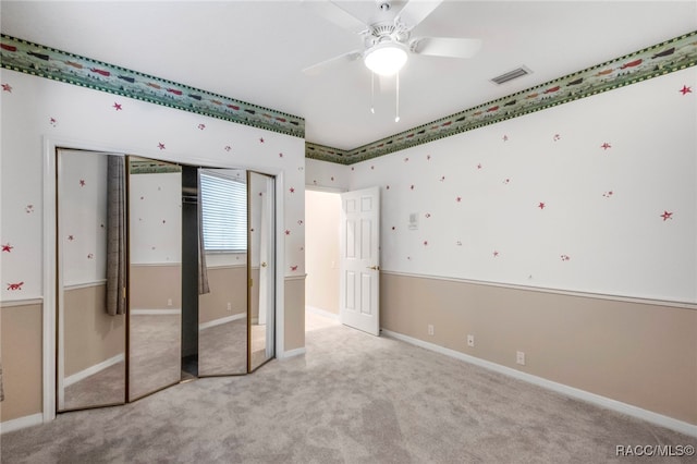 unfurnished bedroom with a closet, ceiling fan, and light colored carpet