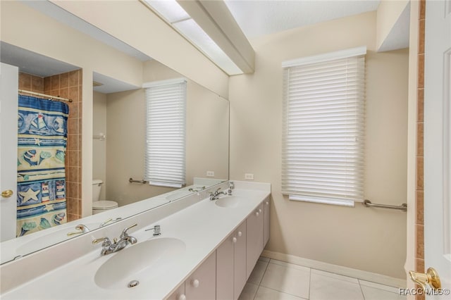 bathroom featuring tile patterned floors, vanity, toilet, and walk in shower