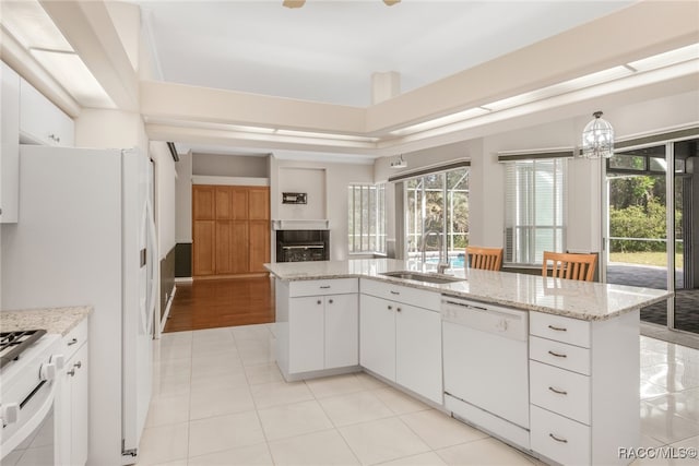 kitchen featuring white appliances, white cabinetry, a wealth of natural light, and sink